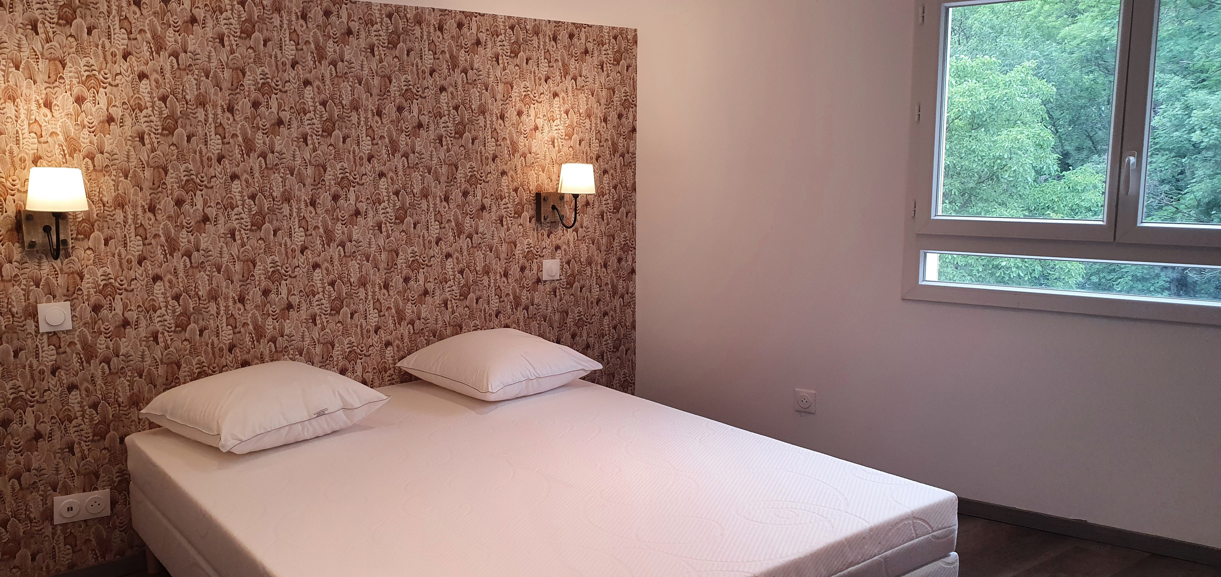 Chambre 5 Chambre avec un mur tete de lit en papier peint et deux appliques