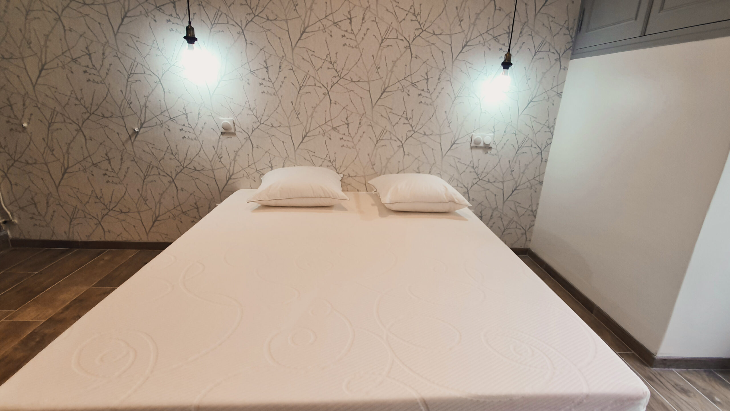 Chambre 1 Chambre avec lit double et deux lampes suspendues en Ardeche