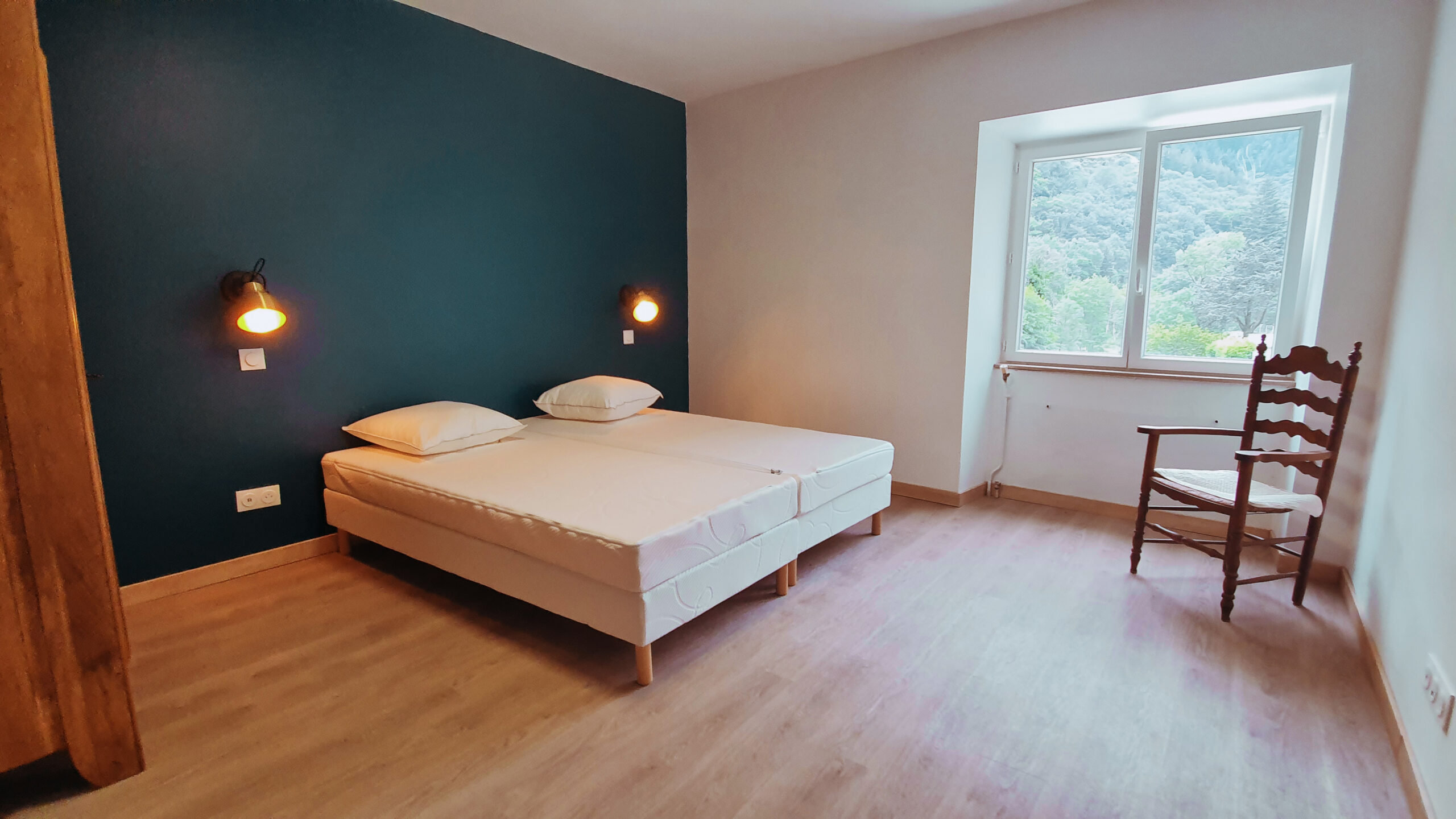 Chambre avec un mur bleu et une fenetre en ardeche
